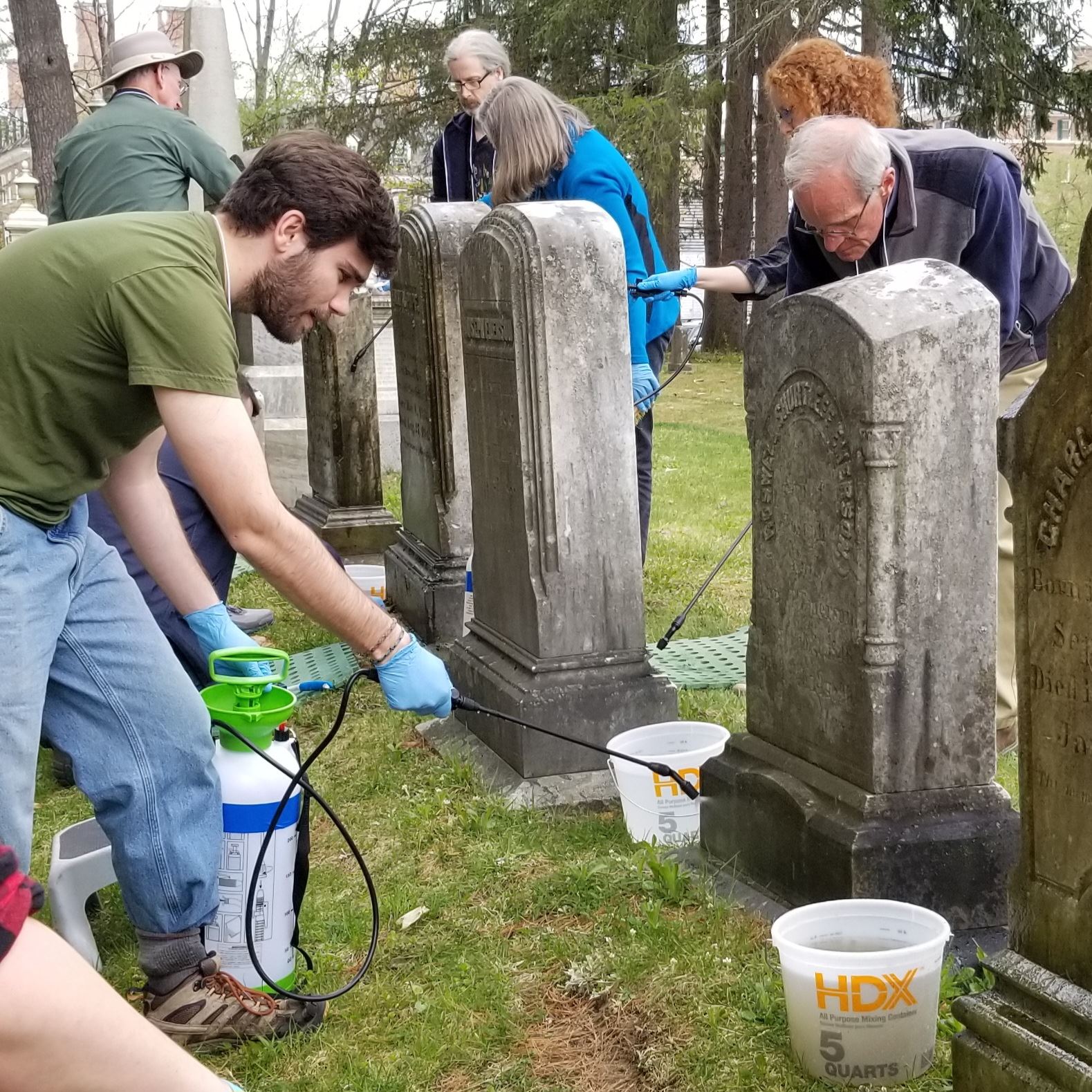 group cleaning cemetery headstones